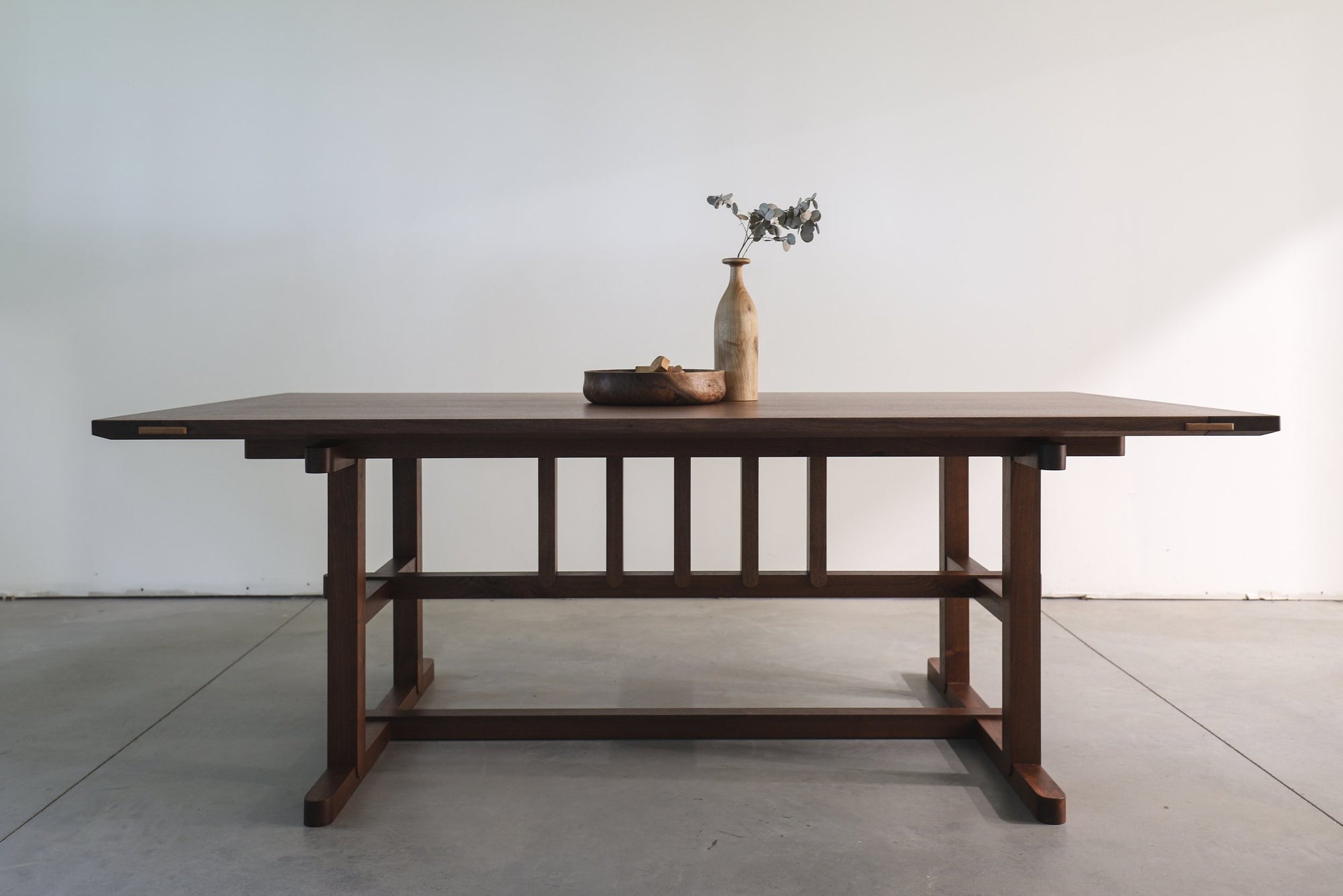 A solid walnut dining table designed by Devin Schaffner and Level